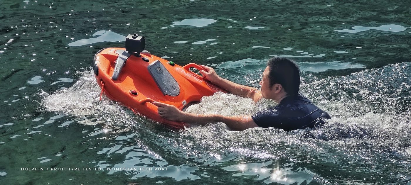 A swimmer holding the handles of the Dolphin 3 as it tows them in